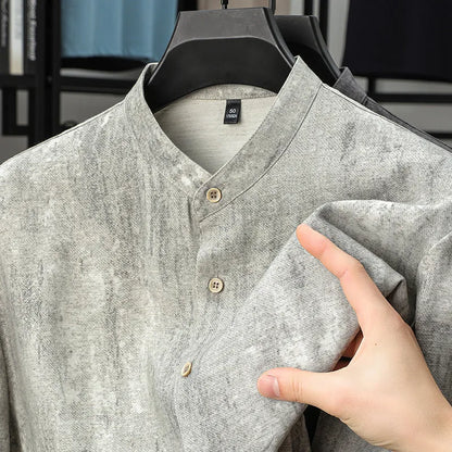 Man wearing a loose-fit grey linen blend short-sleeve shirt with a stand collar.