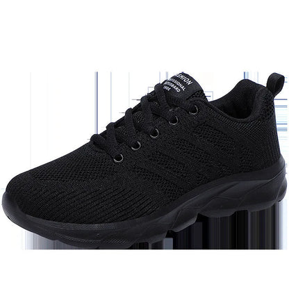 Women's white mesh leisure shoes with lace-up front and low heel on a neutral background.