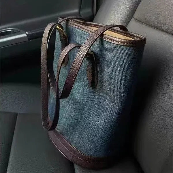 Large blue denim patchwork bucket handbag with one shoulder strap.