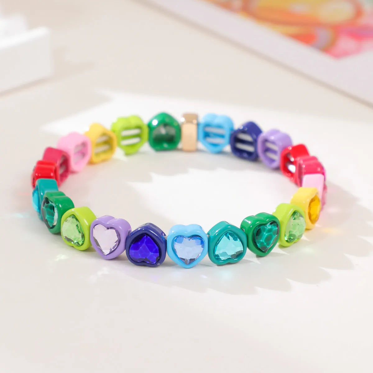 Colourful enamel heart shape on a silver-toned alloy stretch bracelet.