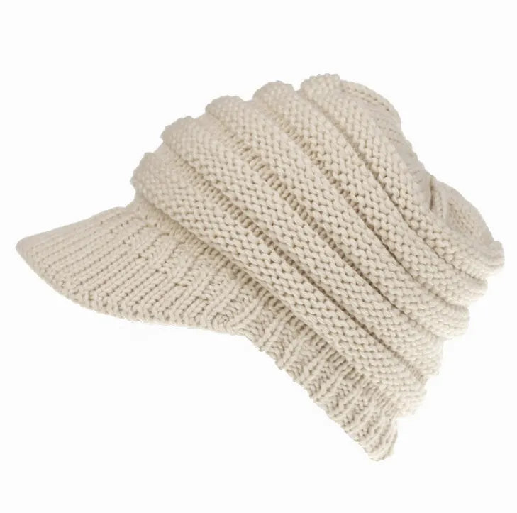 Women's acrylic knitted ponytail beanie in a solid colour, shown on a model with a ponytail.