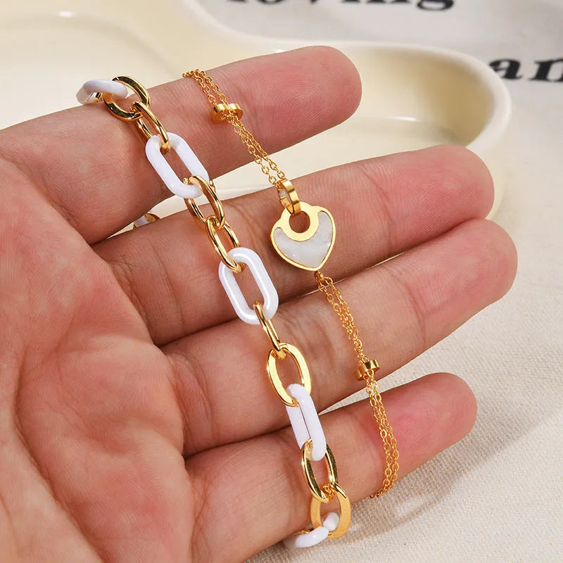 Women's stainless steel bracelet with double-layered heart design and resin accents, showing adjustable clasp and electroplated finish