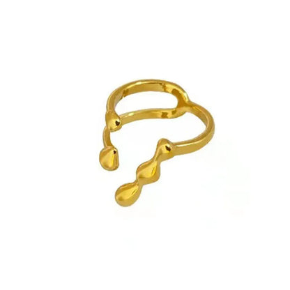 Gold adjustable open ring with spherical details on a woman's hand, showing the 1cm gap.