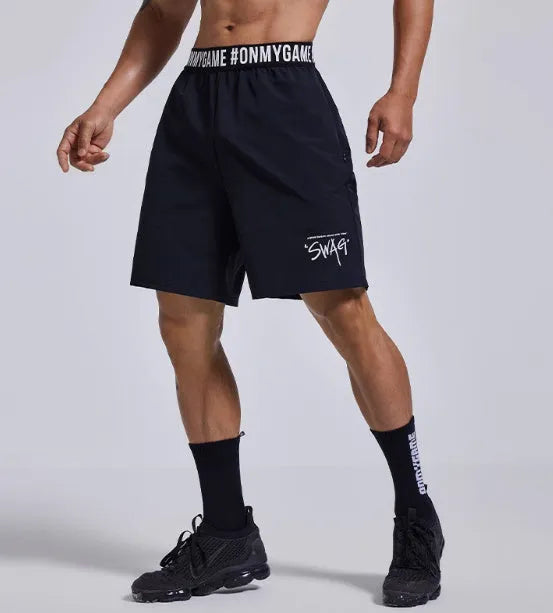 Men's loose black sports shorts with elastic waist and letter detail, shown front and back.