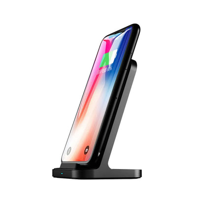 Dark grey vertical aluminium wireless charging stand for iPhone on a desk