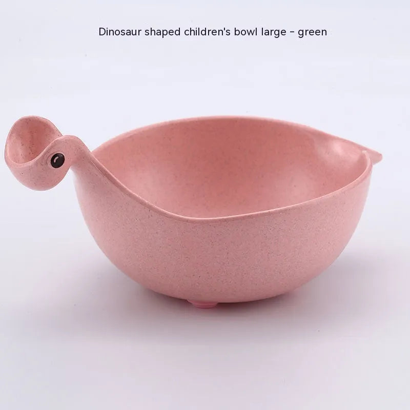 Three colourful dinosaur-shaped bowls made from wheat straw in pink, green, and beige.