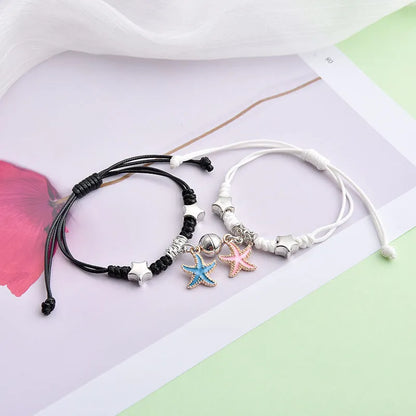 A pair of magnet couple bracelets with a suction clasp, showing various design options like clovers, crowns, and hearts.