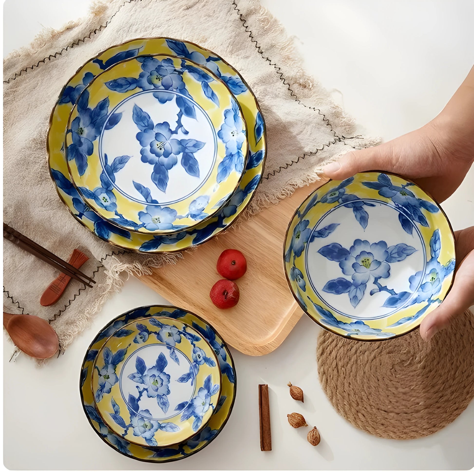 Yellow ceramic tableware set with colourful floral patterns, includes bowls and plates in Japanese style