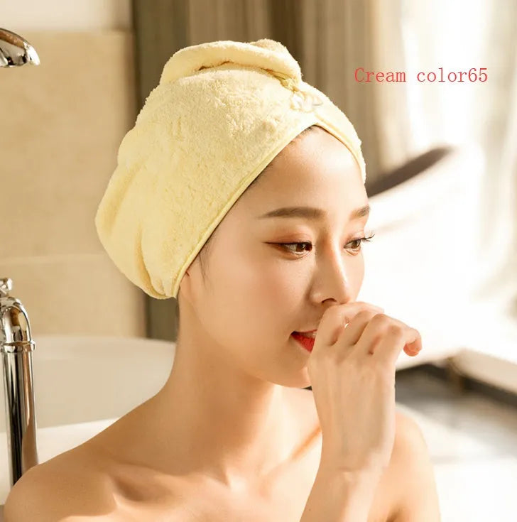 A woman wearing a sky blue microfiber hair dryer cap, with wet hair tucked inside, showing the towel's wrap-around design.