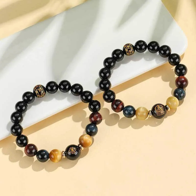 Handcrafted black agate and tiger eye stone beaded bracelet with a central carved zodiac deity charm.