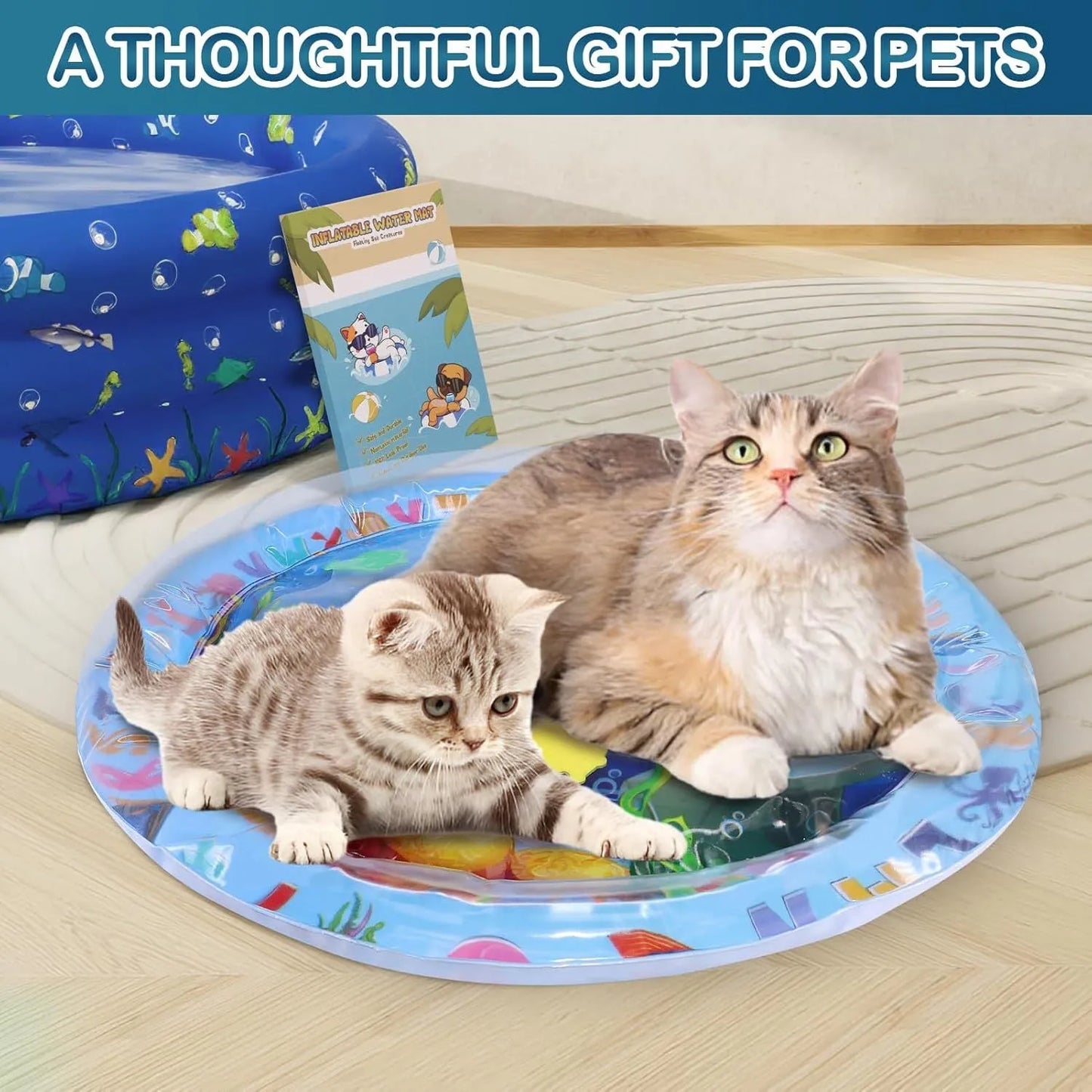 Blue ocean-themed cat water play mat with floating fish toys inside an inflated square border on a wooden floor.