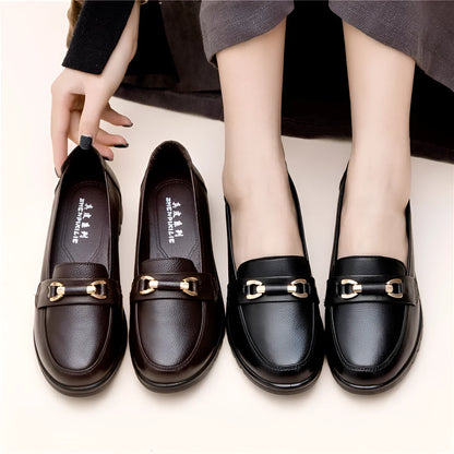 Black casual pumps with round toe, low flat heel, soft bottom, and a subtle metal detail on the upper.