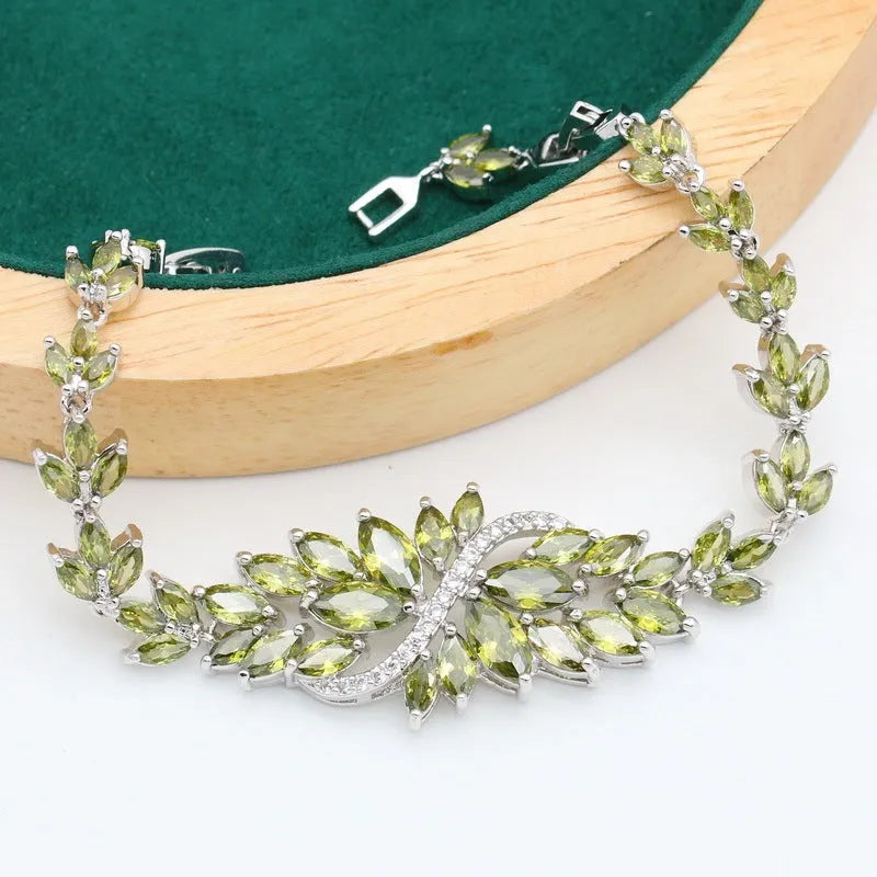 Vintage jewellery set with floral patterns showing necklace, bracelet, earrings and ring in olive green colour