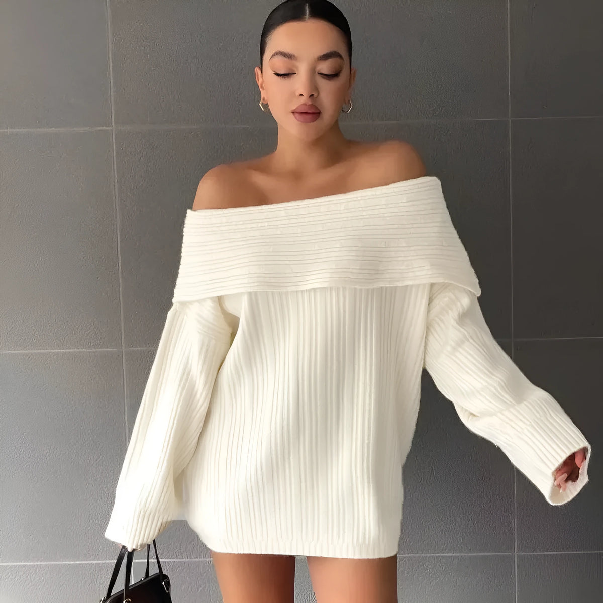 Woman wearing a loose white acrylic knit pullover sweater with long sleeves and an off-neck design.
