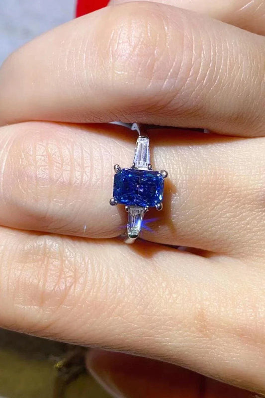 A shimmering 1 carat moissanite ring in a platinum-plated setting with a rectangular shape and sparkling accent stones