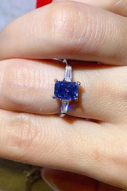 A shimmering 1 carat moissanite ring in a platinum-plated setting with a rectangular shape and sparkling accent stones