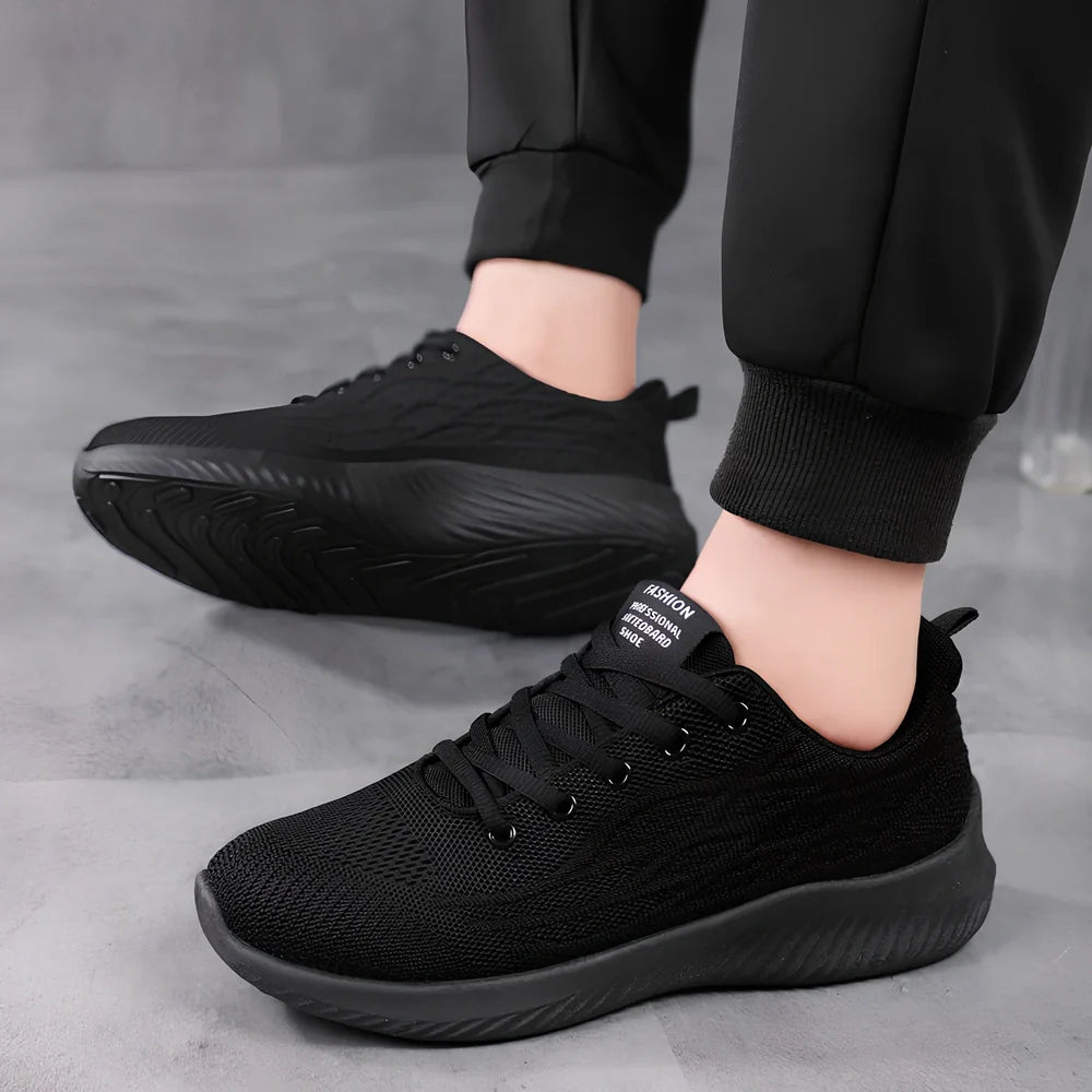Men's black mesh sports shoes with red accent details and flexible PVC sole construction