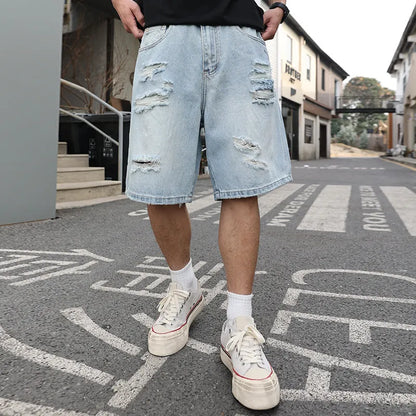 Light blue distressed denim shorts with rips and loose straight fit on mannequin