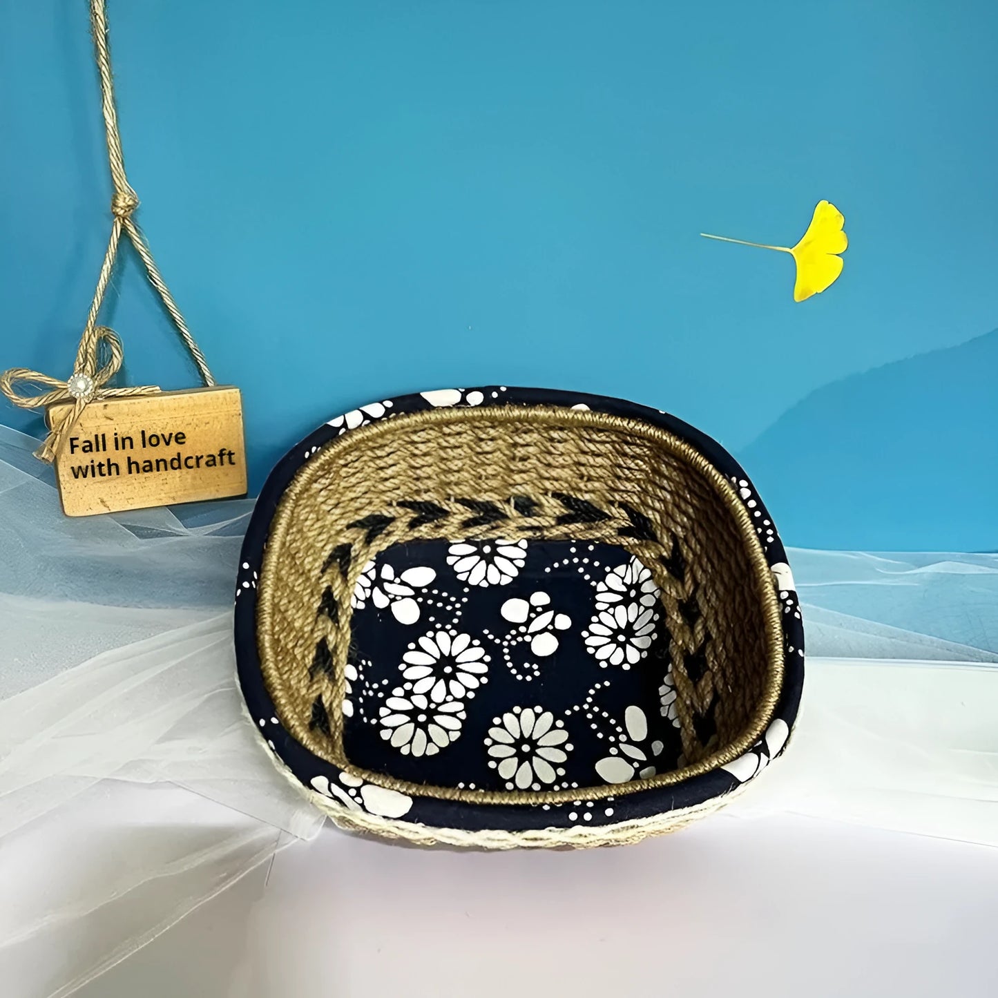 Blue square plastic storage basket with hand-woven sides for organising household items.