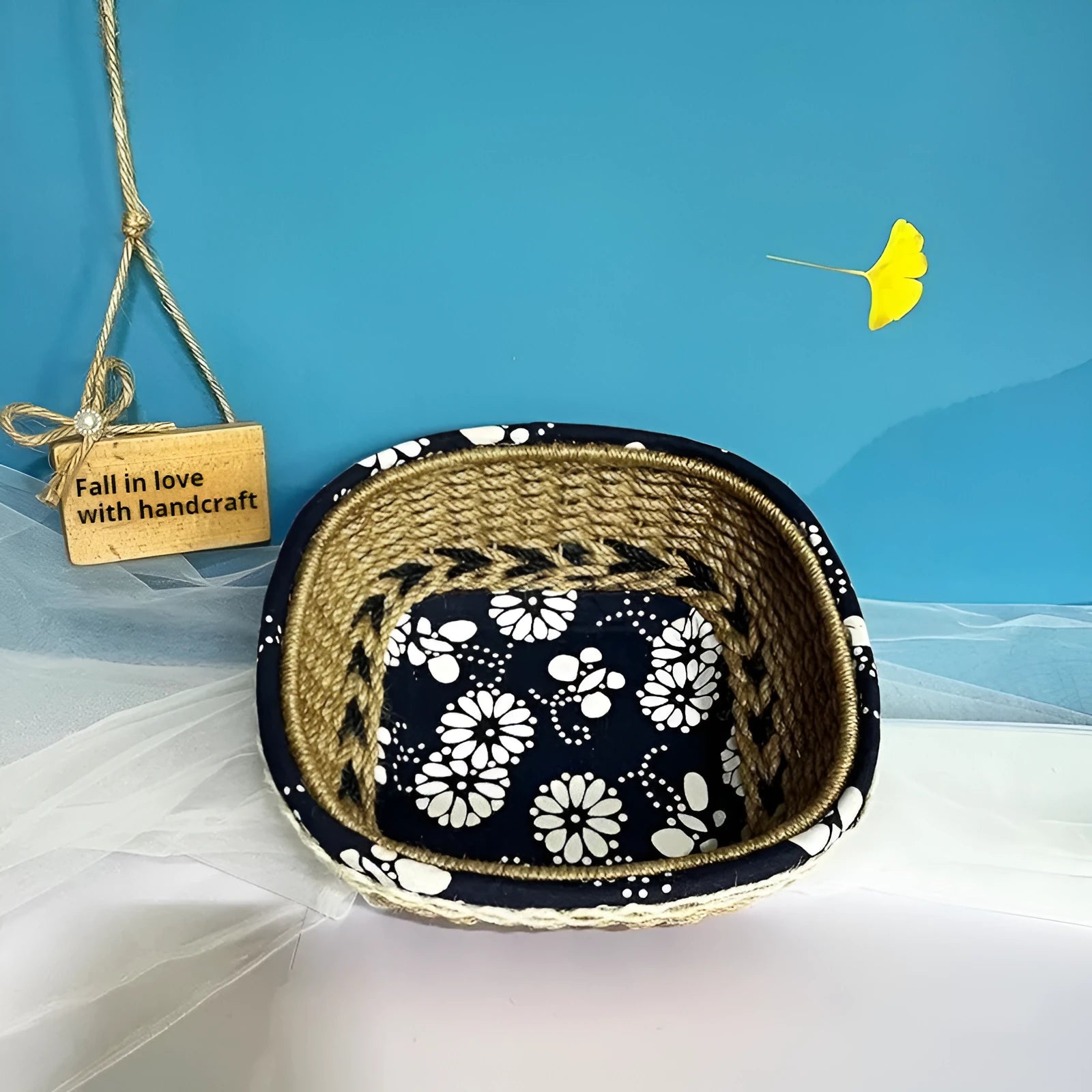 Blue square plastic storage basket with hand-woven sides for organising household items.