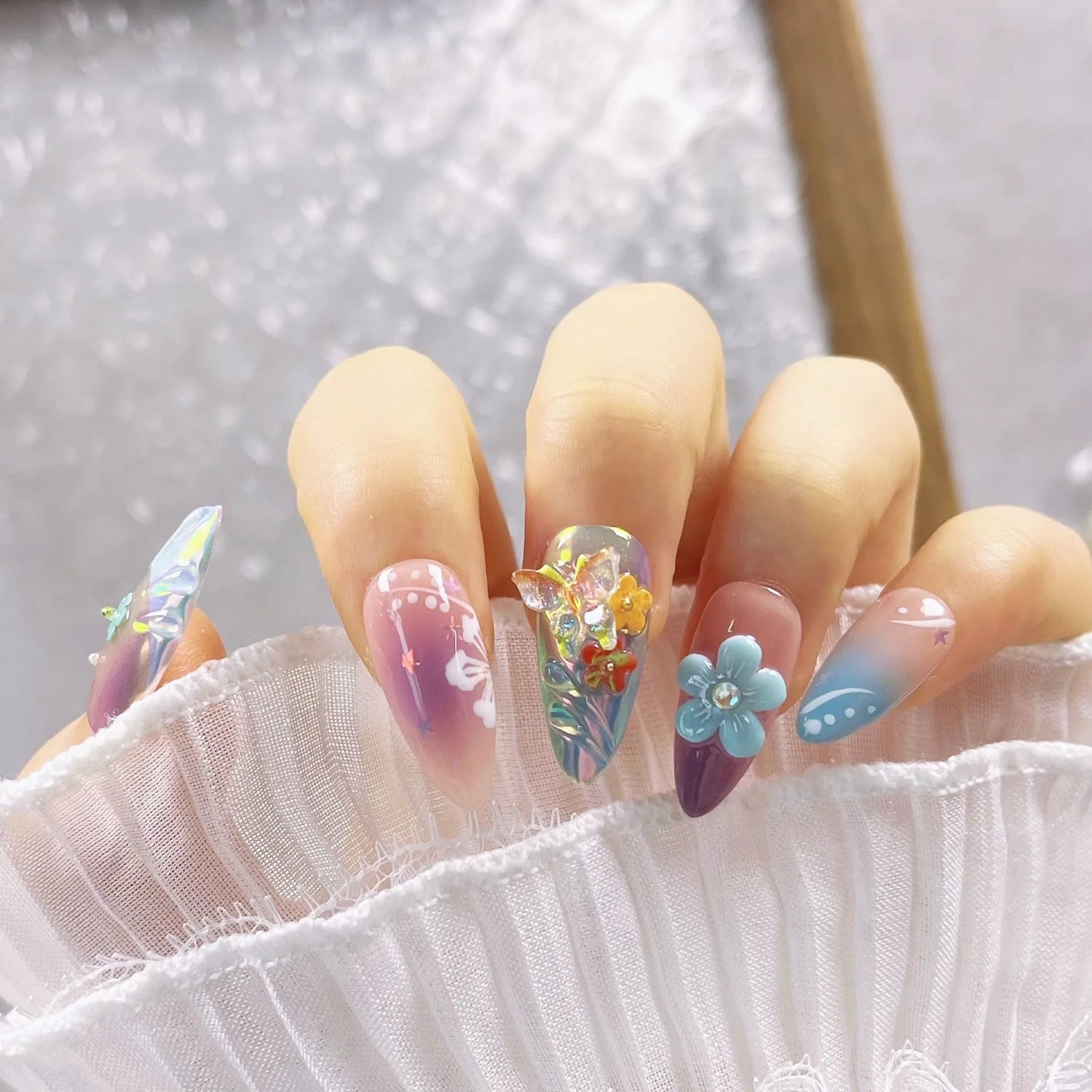 Handmade nail art sculpture set with embossed flower and butterfly designs in four sizes for almond-shaped nails