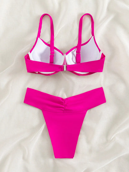 Women's solid colour split bikini swimsuit in fluorescent pink on a mannequin.