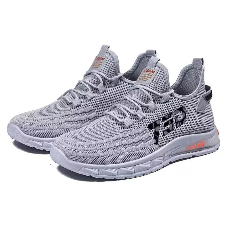 Low-top casual sneakers with striped mesh upper and flat plastic sole in grey colour.