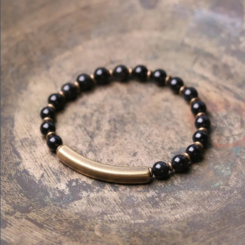 Layered stone and brass ethnic bracelet for men and women on a wrist.