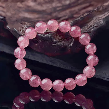 A women's bracelet made of polished strawberry quartz crystal beads in one of three size options.