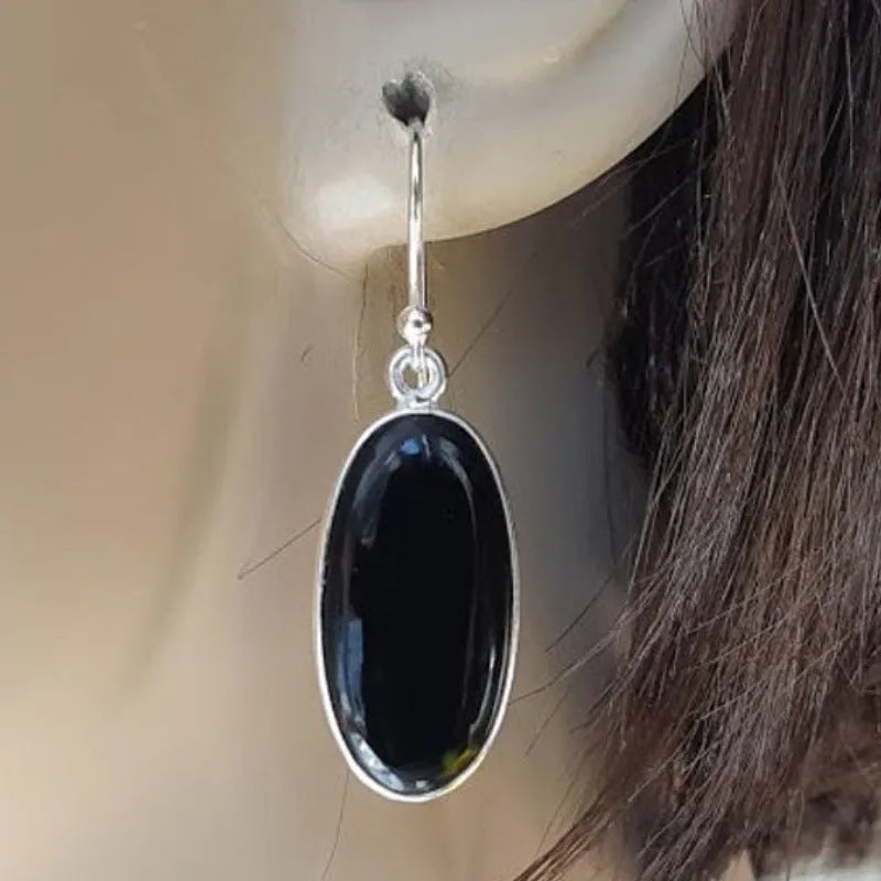 A pair of women's silver-plated alloy earrings with an oval black agate geometric pendant.