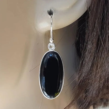 A pair of women's silver-plated alloy earrings with an oval black agate geometric pendant.