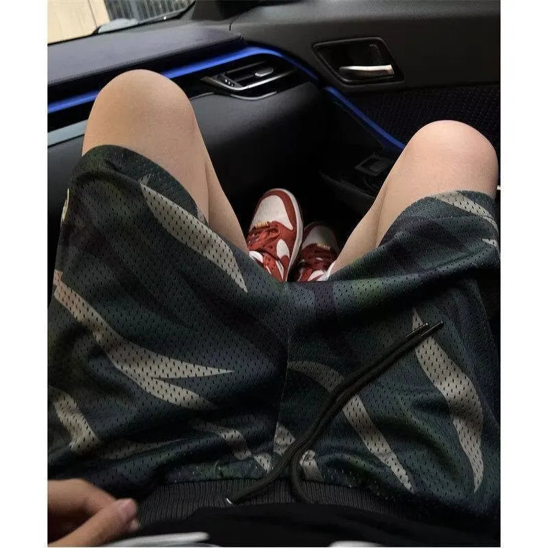 Men's camouflage patterned straight-leg mesh shorts laid flat, showing cotton blend fabric and relaxed fit.
