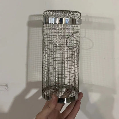 Silver iron wire rolling cylinder BBQ basket with mesh design and a hook for grilling.
