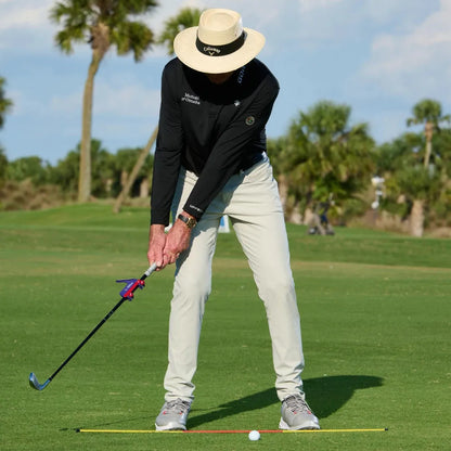 Plastic golf swing plane simulator training aid on a practice mat.
