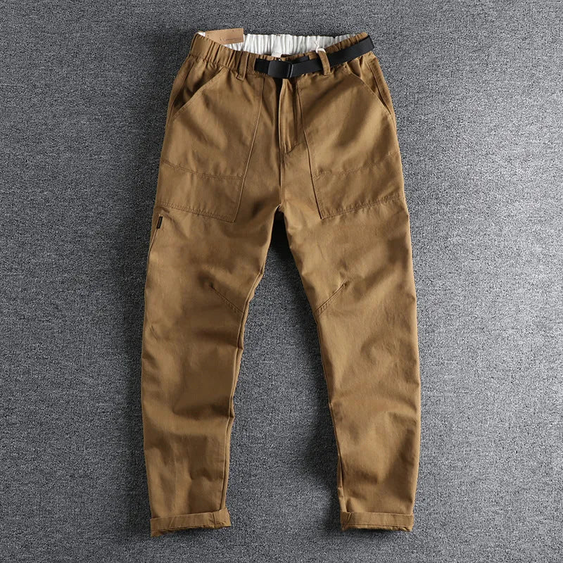 Men's khaki work trousers with a three-dimensional cut and an N I buckle belt on a hanger.