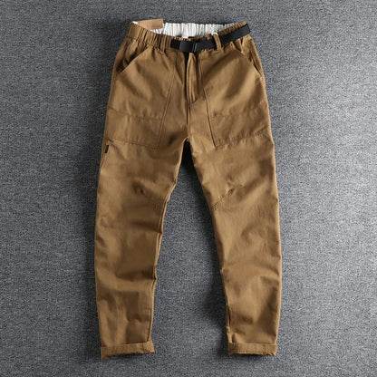 Men's khaki work trousers with a three-dimensional cut and an N I buckle belt on a hanger.