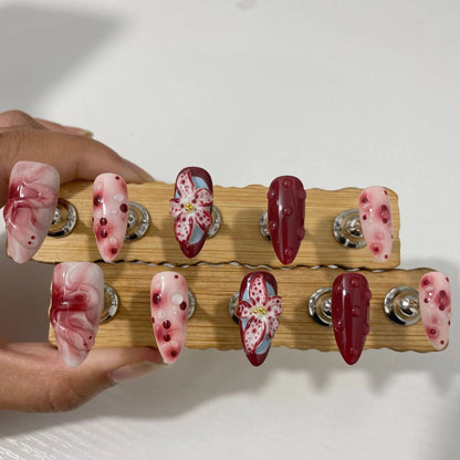 Hand-painted 3D carved nail wraps in Almond colour showing floral and geometric designs for mid-length manicures.