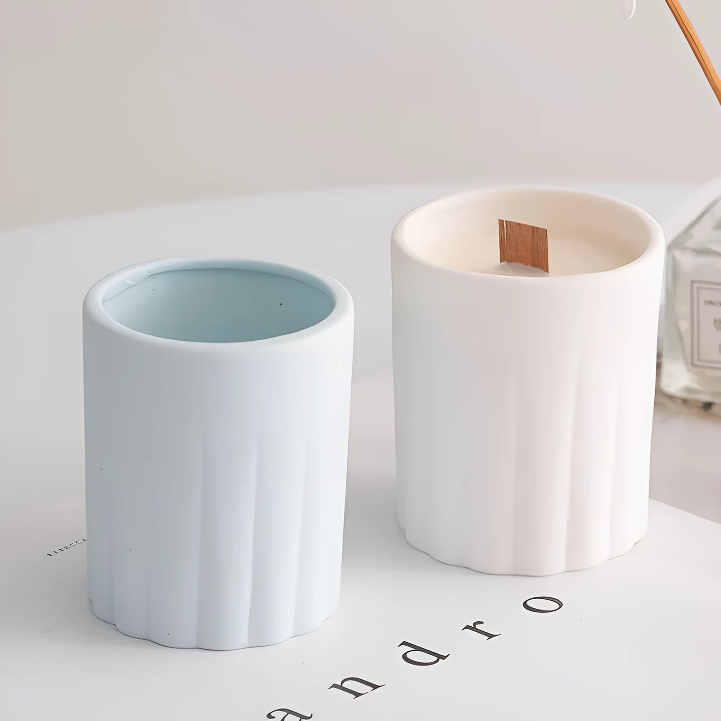 Set of ten round white ceramic candlesticks with minimalist relief patterns on a dining table