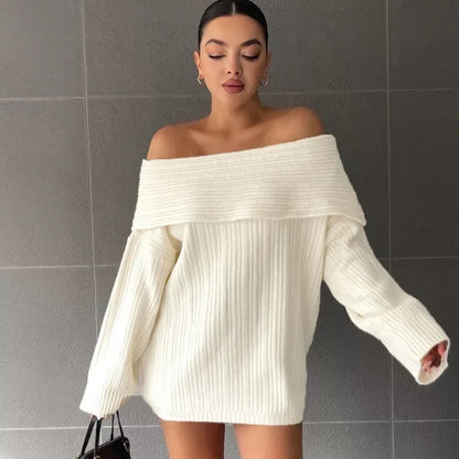 Woman wearing a loose white acrylic knit pullover sweater with long sleeves and an off-neck design.