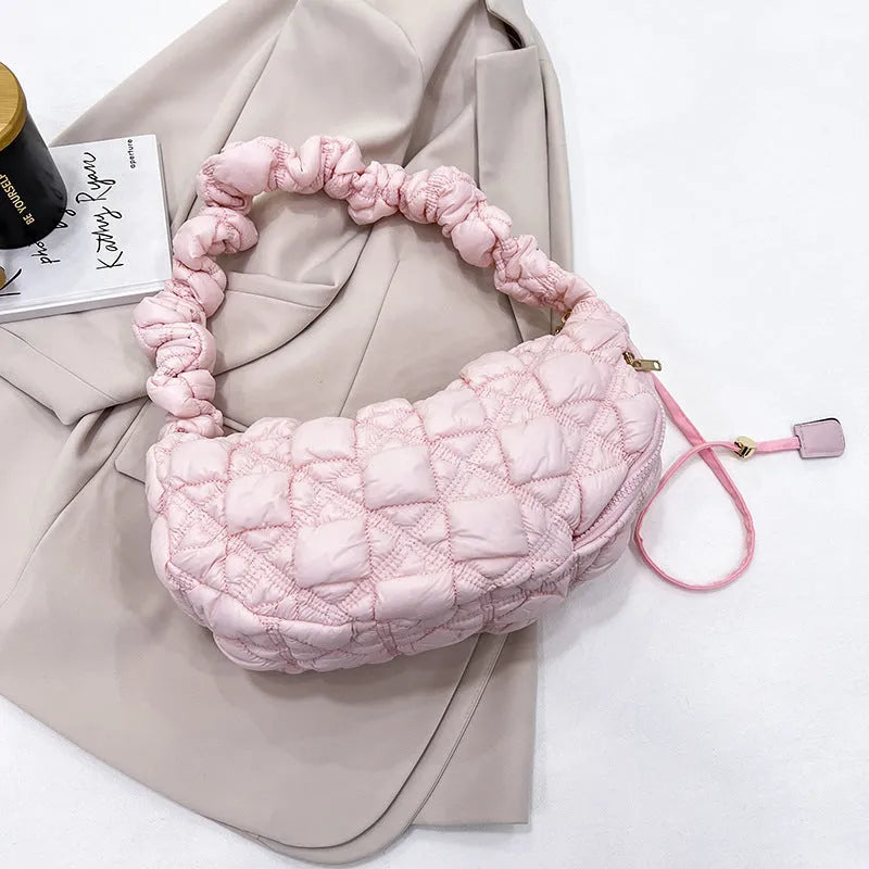 Women's light grey nylon underarm messenger bag with adjustable long strap, shown worn crossbody.