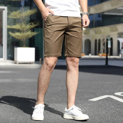 Man wearing loose-fit beige fifth pants with an elastic waistband, showcasing the mid-length casual style.