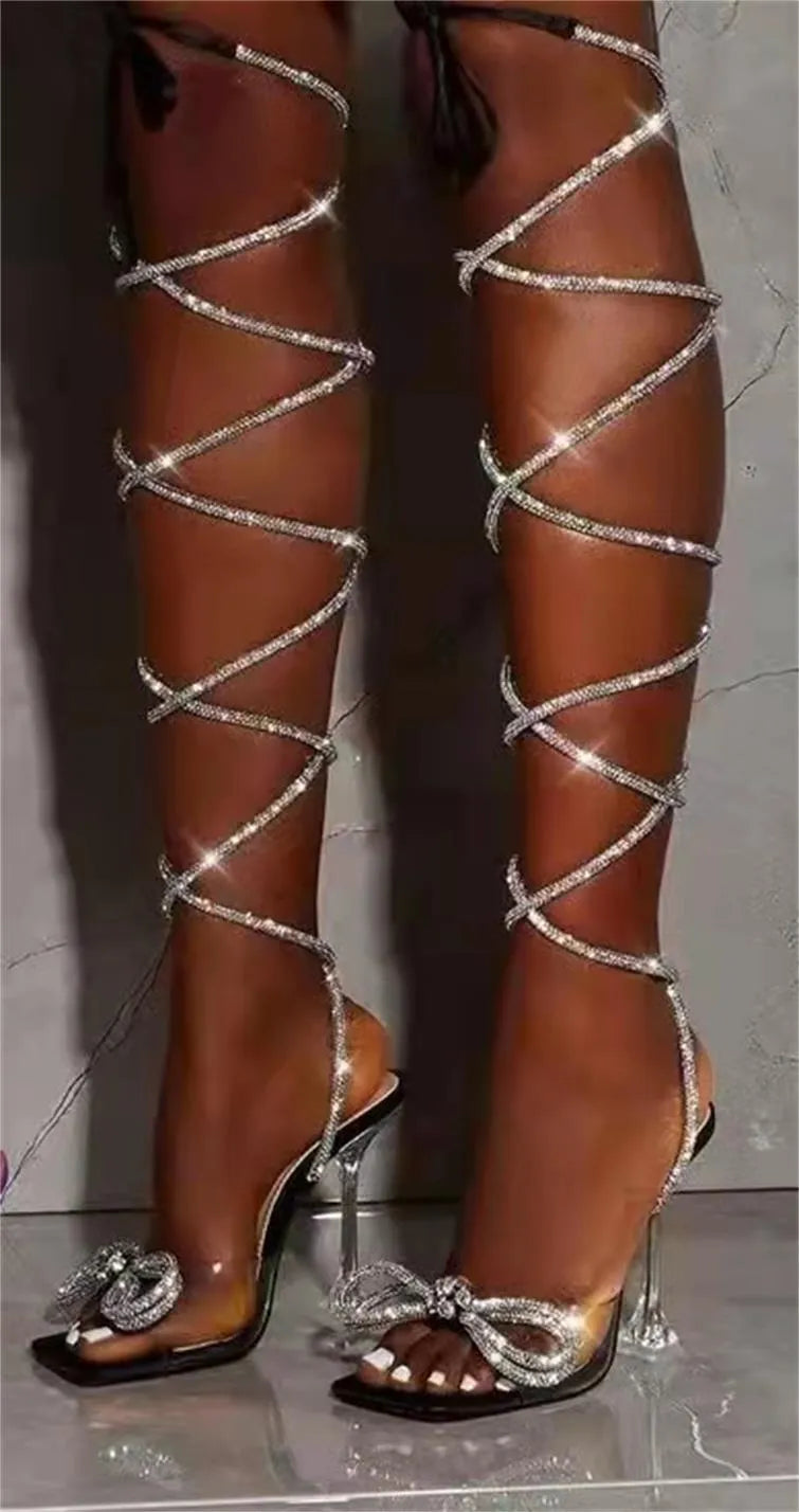 Black plus-size women's strappy sandals with glittering rhinestone straps and a square toe.