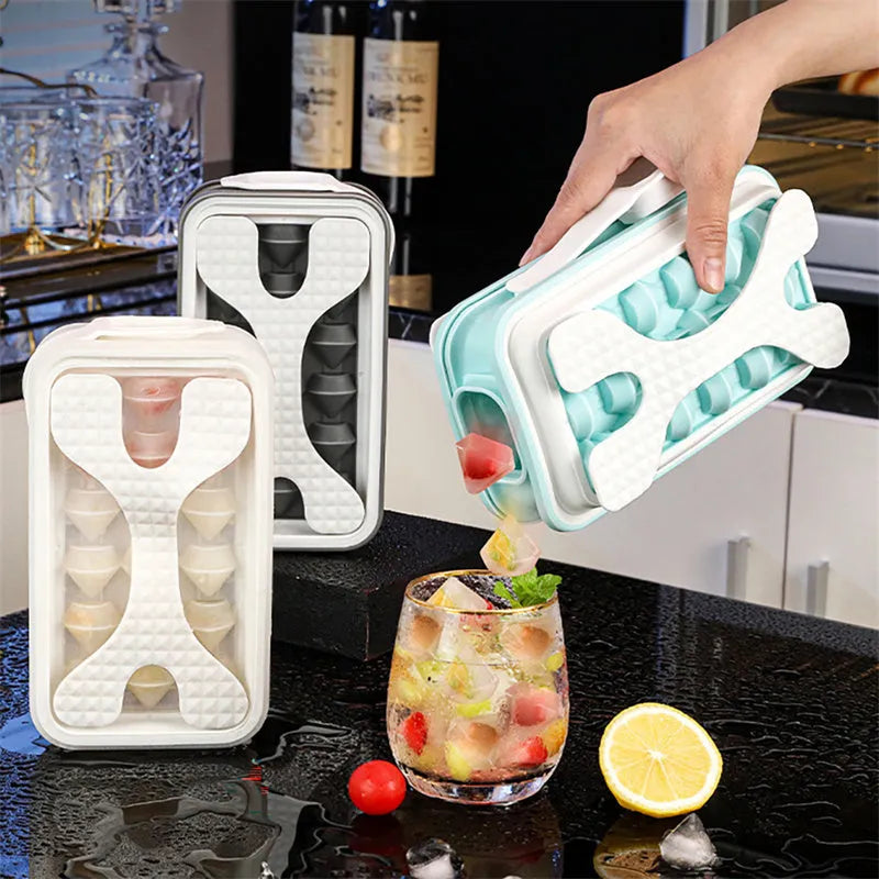 Light grey silicone ice ball mould and water bottle with lid on a kitchen counter.