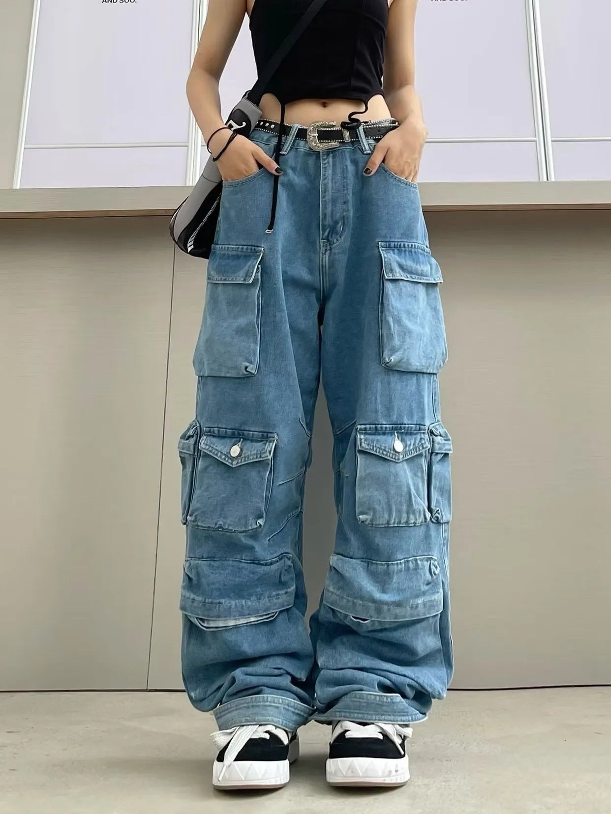 Blue high waist wide leg denim trousers with multiple pockets on a mannequin