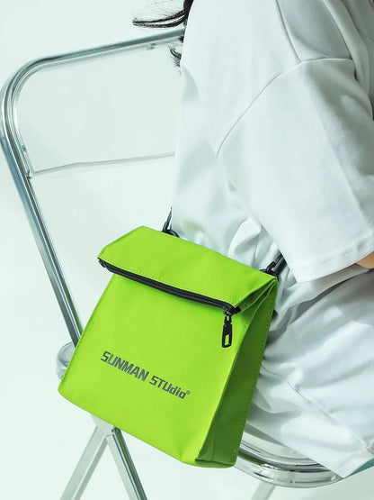 Polyester Oxford fabric messenger-style backpack in khaki colour with visible stitching and a crossbody strap.