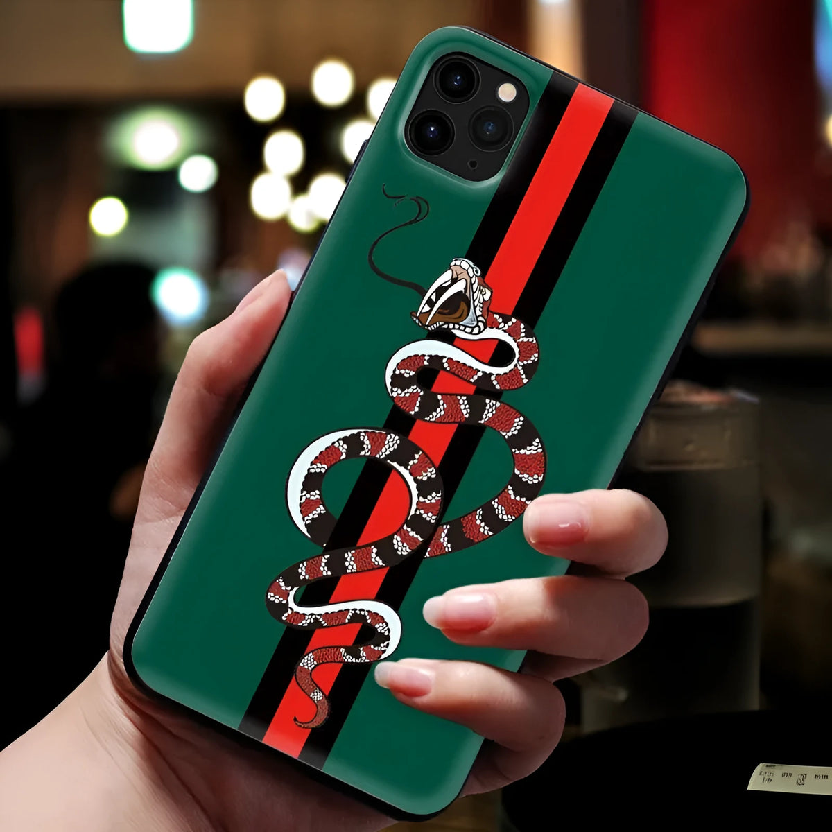 Black frosted silicone iPhone case with cartoon snake design shown on mobile phone