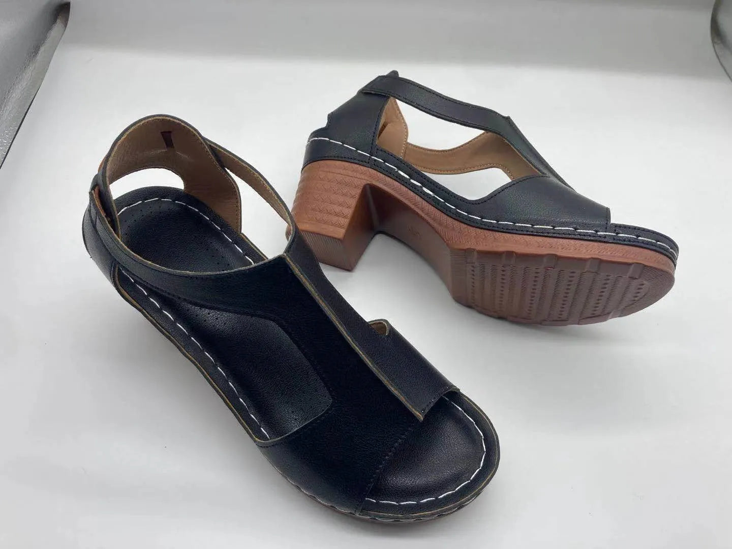 Women's beige peep toe wedge sandals with a buckle strap and low heel on a white background.