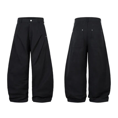 Men's black cotton pleated casual trousers with a loose-fitting wide-leg silhouette.
