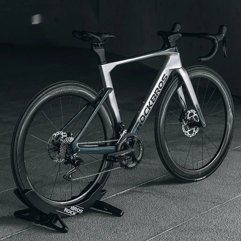 A black wall-mounted ABS plastic bracket holding a mountain bike vertically for storage.