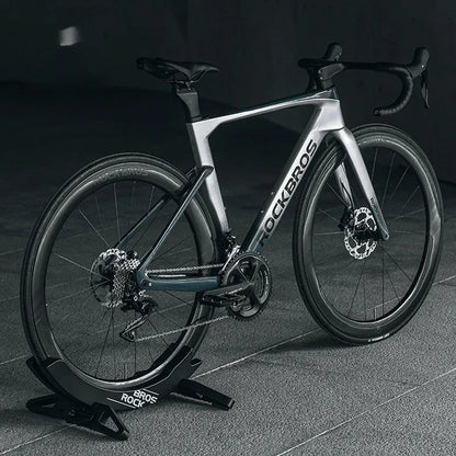 A black wall-mounted ABS plastic bracket holding a mountain bike vertically for storage.